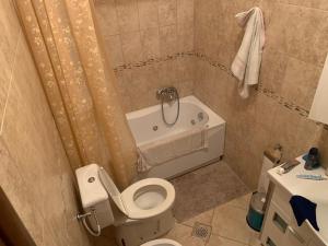 a bathroom with a toilet and a tub and a sink at Apartment with swimmingpool, seaview and large terrace, 1st floor, min 2 persons in Dobrota