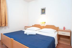 1 dormitorio con 1 cama grande con manta azul en Holiday Home Sansevic en Stari Grad