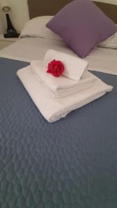 a red rose on a white napkin on a bed at GaLu - Piccolo appartamento in Costiera Sorrentina,Amalfitana in Termini