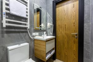 a bathroom with a sink and a toilet and a mirror at Ribas Rooms Bila Tserkva in Bila Tserkva +40 photos