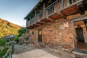 a brick building with a balcony on top of it at Casa Do Concello in Arnado