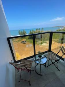 a balcony with a table and chairs and the ocean at Travel Time Homestay in Huxi