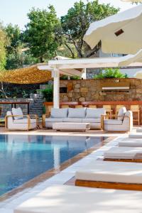 a pool with white lounge chairs and an umbrella at Odette Bodrum in Bodrum City