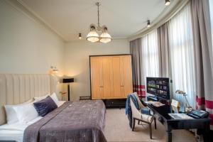 a hotel room with a bed and a desk in a room at Astoria Hotel in Lviv