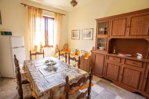 a dining room with a table and a kitchen at Casa del Duca - Goelba in San Giovanni