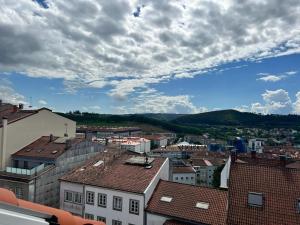 a view of a city with buildings and a cloudy sky at CONCHEIROS 5 APARTAMENTOS TURISTICOS in Santiago de Compostela