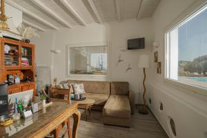 un soggiorno con divano e tavolo di Casa Nostra Mykonos Boutique Rooms & Studios a Glastros