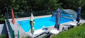 a swimming pool with two umbrellas and two chairs at Sand-Hof 