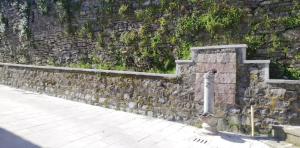 a stone wall next to a sidewalk at Casa caratteristica nel Parco del Cilento in Cuccaro Vetere