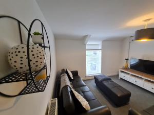 a living room with a couch and a mirror at Perfect Location 3 Bed Serviced apartment with Bike Storage for BPW. Close to Brecon Beacons in Merthyr Tydfil