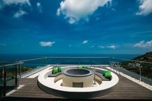 einen Whirlpool auf einer Terrasse mit Meerblick im Hintergrund in der Unterkunft Villa Seawadee - luxurious, award-winning design Villa with amazing panoramic seaview in Strand Chaweng Noi