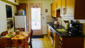 uma cozinha com uma mesa e uma cozinha com um frigorífico em Gîte L'Escapade em Saint-Saturnin-dʼApt