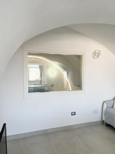 una sala de estar con una ventana en una pared blanca en B & B Marina en Procida