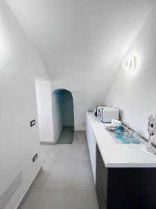 a white kitchen with a counter and a microwave at B & B Marina in Procida