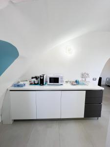 a white kitchen with a counter with a microwave at B & B Marina in Procida