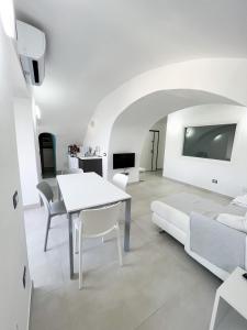 a white living room with a table and a couch at B & B Marina in Procida