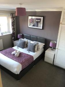 ビスターにあるSt Anne's Serviced Accommodation - Bicester Oxfordshireのベッドルーム(紫の毛布を使用した大型ベッド1台付)