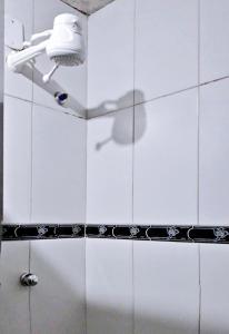 um chuveiro na casa de banho com azulejos brancos em Solar Hostel Beach Copacabana no Rio de Janeiro