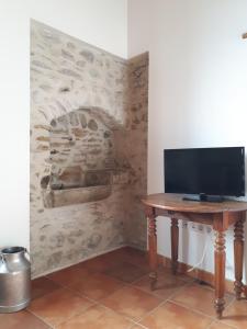 a television sitting on a wooden table in a room at Bel appartement rénové dans maison bigourdane in Pouzac