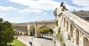 eine Person, die auf einer Brücke sitzt in der Unterkunft JOLI PETIT STUDIO A PROXIMITE DES ARCEAUX, MONTPELLIER. in Montpellier