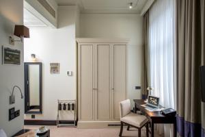 a room with a desk and a cabinet with a computer at Astoria Hotel in Lviv