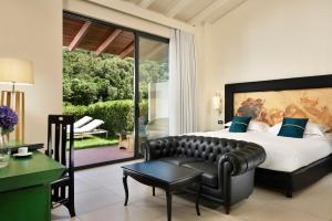 una camera con un grande letto e un divano di Argentario Lagoon Resort & Spa a Monte Argentario
