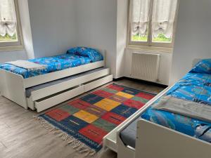 - une chambre avec 2 lits et un tapis dans l'établissement Baciccia a maina, à Chiavari