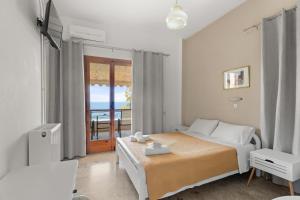a bedroom with a bed and a view of the ocean at Dimitra's Studios in Stoupa