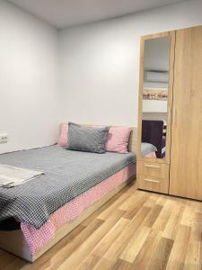 Schlafzimmer mit einem Bett und einem Spiegel in der Unterkunft Apartment Cozy Home 3 in Ruse