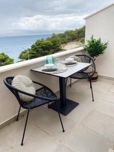 d'une table et de chaises sur un balcon donnant sur l'océan. dans l'établissement Blue View Studio, à Lokva Rogoznica