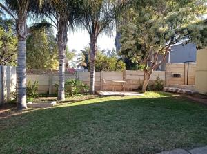 a yard with palm trees and a fence at Kleine Nessie in Worcester
