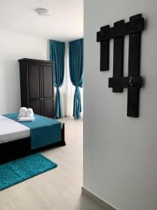 a bedroom with a bed and a cross on the wall at Pensiunea DeeaMar in Năvodari