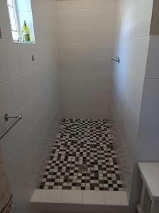 y baño con ducha de azulejos blancos y negros. en Kleine Nessie, en Worcester