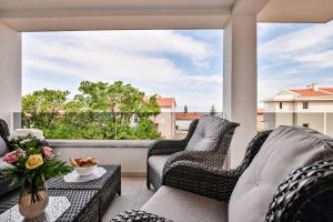 balkon z wiklinowymi krzesłami i dużym oknem w obiekcie Luxury Apartment Nina with sea view w mieście Sveti Anton