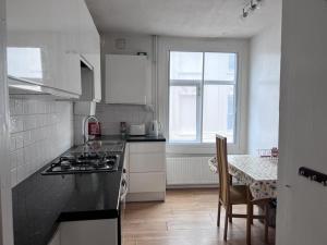 a kitchen with a stove and a table with chairs at Harbour Street Rooms in Kent