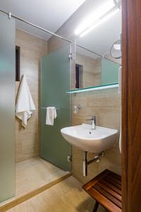 een badkamer met een wastafel en een spiegel bij Epico Seafront & Garden Apartments in Olimp
