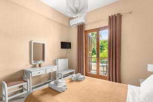 a bedroom with a bed and a tv and a window at Dimitra's Studios in Stoupa