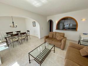 una sala de estar con un sofá y una mesa en Duplex Vistamar X2154, en Benitachell