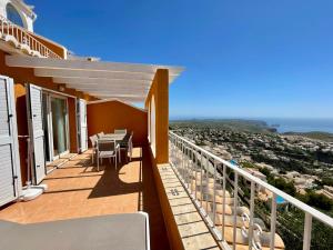 Un balcón de una casa con una mesa y sillas. en Duplex Vistamar X2154, en Benitachell