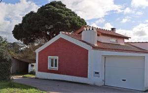 una casa roja y blanca con garaje en Casa de campo a 5 minutos da praia en Atouguio