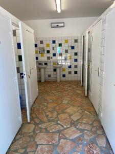 baño con 2 lavabos y pared de azulejos en Hebergements Insolites - Etretat Aventure, en Les Loges