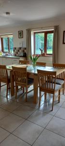 a dining room with a table and chairs and a kitchen at 1 Barge Cottage in Narborough