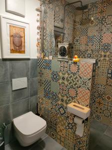 a bathroom with a toilet and a tile wall at Löwensteiner Berge in Löwenstein