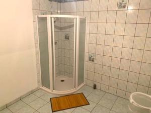 La salle de bains est pourvue d'une douche et d'un tapis en bois. dans l'établissement Petite maison lorraine avec cheminée et jardin, à Saint-Mihiel