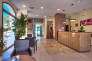 a lobby with a reception desk and chairs in a building at Hotel Pine in Tivat