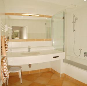 uma casa de banho com um lavatório e um chuveiro em Landhotel Kielhuberhof em Ramsau am Dachstein