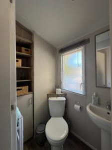 a bathroom with a white toilet and a sink at Sunnycott Caravan Park in Cowes +71 photos