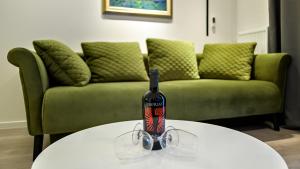 a bottle of wine sitting on a table in front of a couch at Apartman Nostra 1 in Zagreb