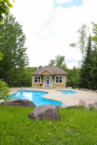 une maison avec 2 piscines dans une cour dans l'établissement Plage et piscine au Mont Blanc, à Saint-Faustin–Lac-Carré