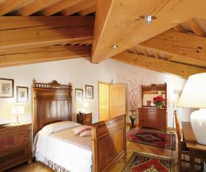 a bedroom with a wooden bed and a wooden ceiling at Villa Busta Hotel in Montebelluna